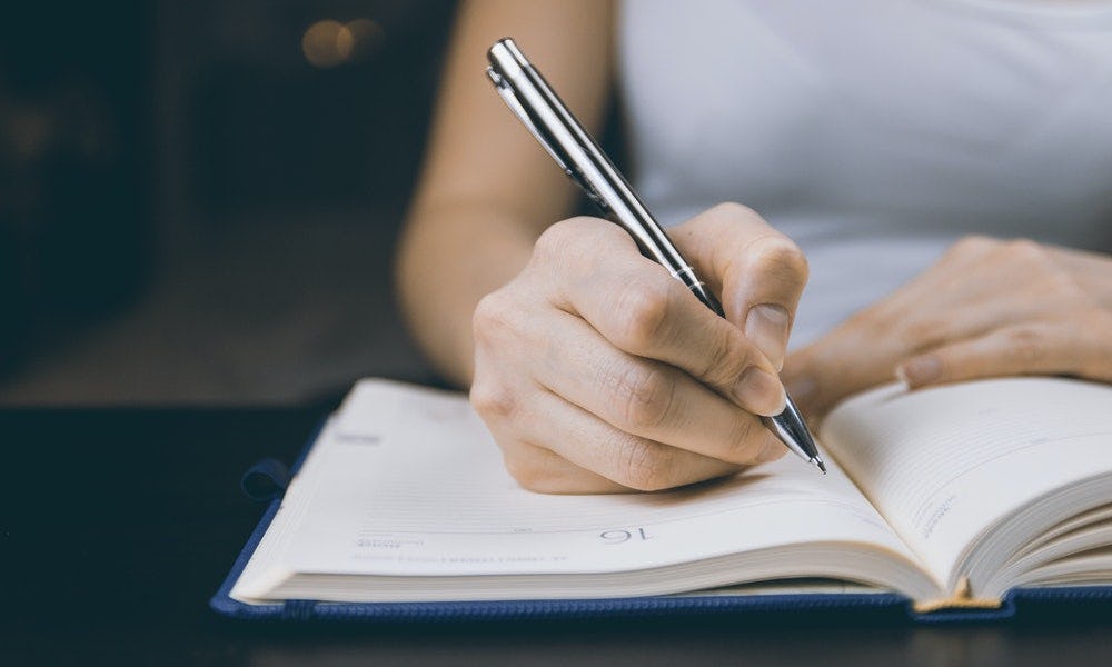 Persona elabora una agenda para organizar una reunión de trabajo